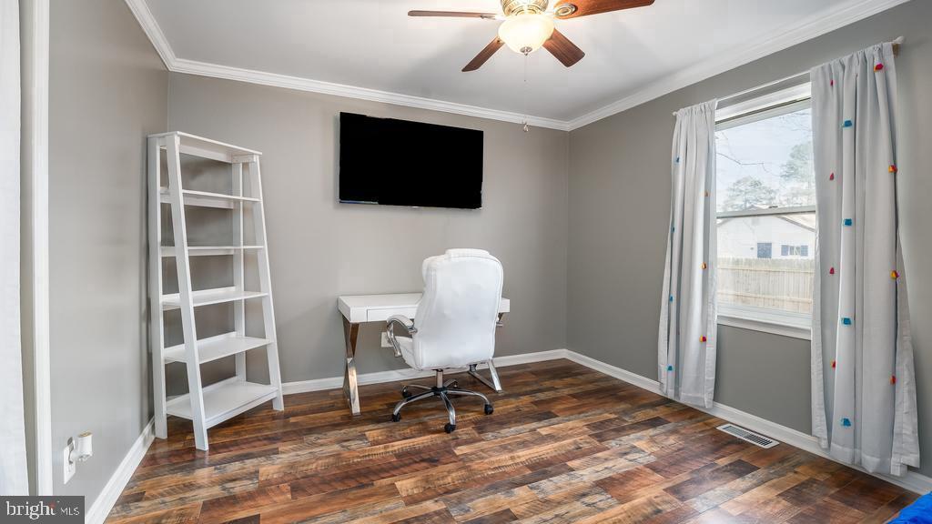 128 7th Street Colonial Beach, VA 22443 - Photo 21 of 32 a workspace with wooden floor a flat screen tv and windows