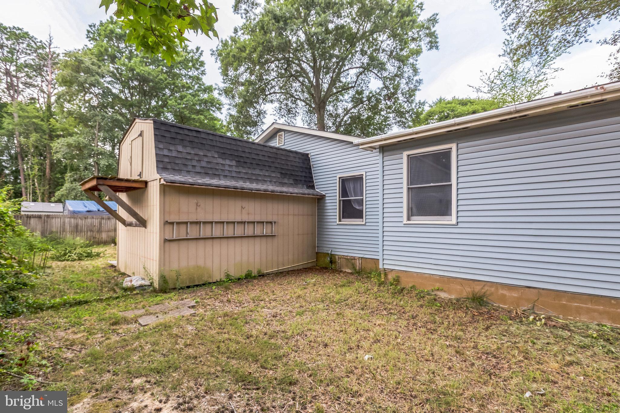 128 7th Street Colonial Beach, VA 22443 - Photo 29 of 32 a view of a house with a large tree and wooden fence