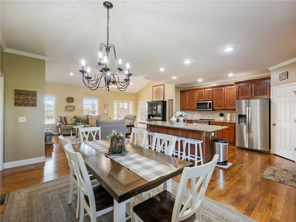 7657 Pea Ridge Road Lula, GA 30554 - Photo 10 of 76 a view of a dining room with furniture a chandelier and wooden floor