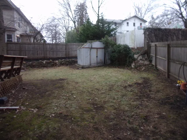 a backyard of a house with table and chairs
