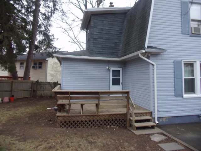 a view of a house with a backyard and chairs