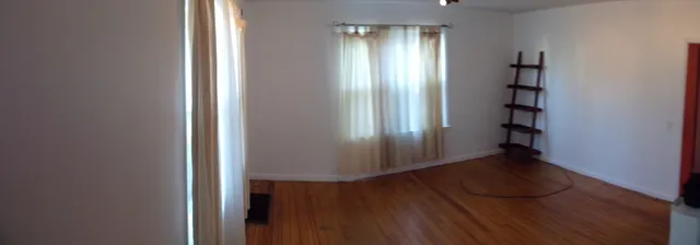 an empty room with wooden floor and closet
