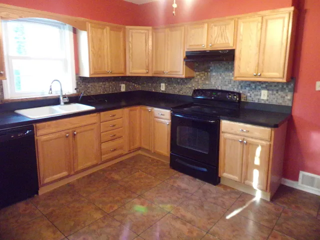 a kitchen with a sink stove and cabinets