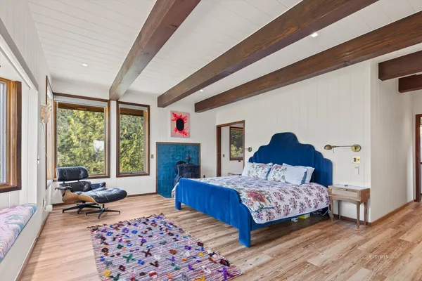 a bedroom with a bed a couch and a window with outer view