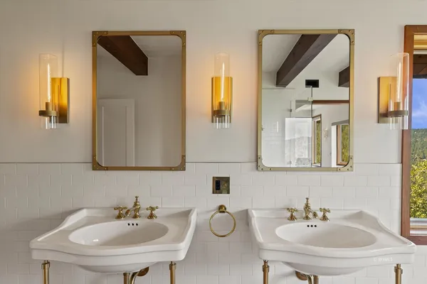 a bathroom with double vanity sinks and a mirror
