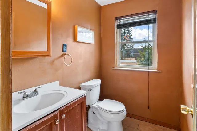 a bathroom with a sink toilet and window