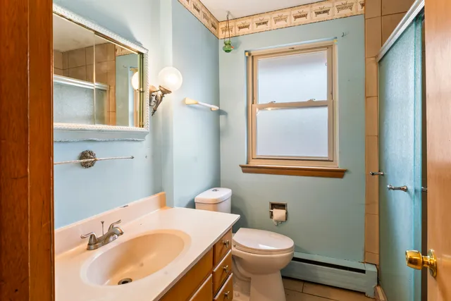 a bathroom with a sink and mirror with toilet