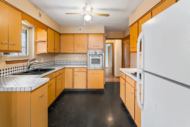 a kitchen with stainless steel appliances granite countertop a sink a stove and a refrigerator