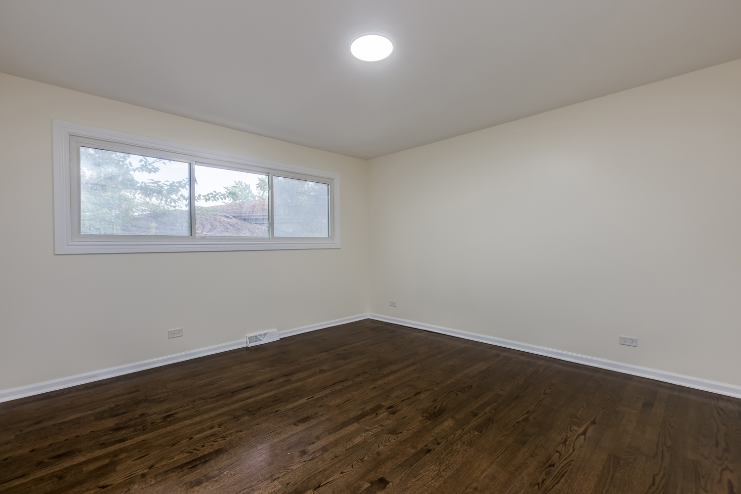 8717 Gross Point Road Skokie, IL 60077 - Photo 17 of 36 an empty room with wooden floor and windows