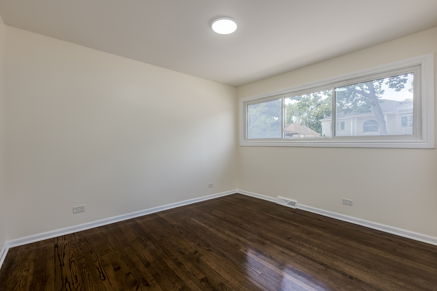 8717 Gross Point Road Skokie, IL 60077 - Photo 20 of 36 an empty room with wooden floor and windows