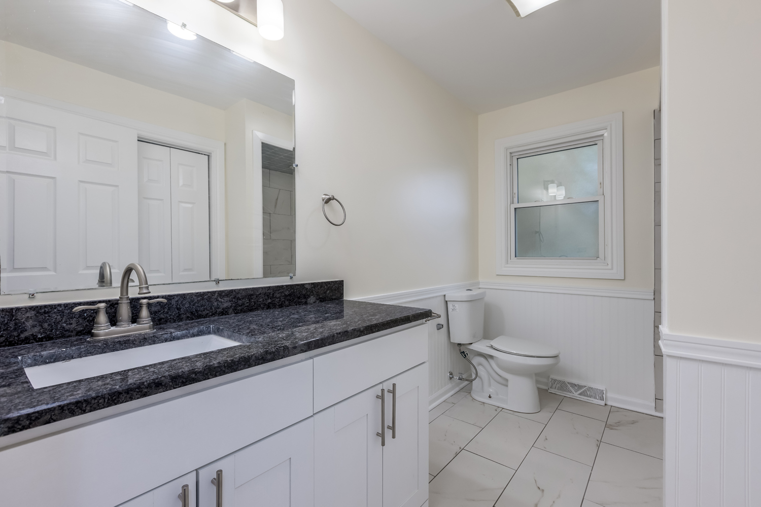 8717 Gross Point Road Skokie, IL 60077 - Photo 24 of 36 a bathroom with a granite countertop sink a toilet and mirror