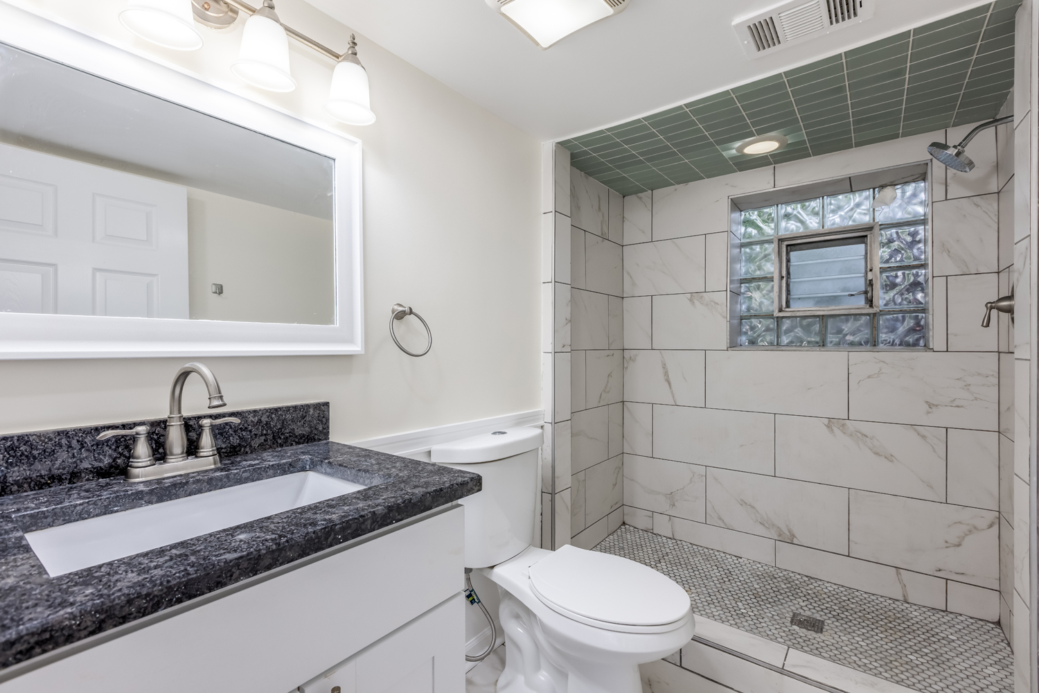 8717 Gross Point Road Skokie, IL 60077 - Photo 31 of 36 a bathroom with a granite countertop toilet sink and mirror