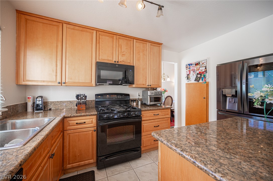 718 Rusty Spur Drive Henderson, NV 89014 - Photo 18 of 50 Culinary adventures await in this kitchen featuring abundant wood cabinetry and generous counter space.
