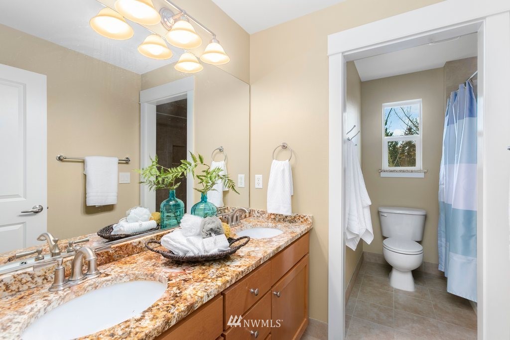 552 Mount Baker Place Northeast Renton, WA 98059 - Photo 19 of 25 a bath room with a granite countertop sink and a mirror