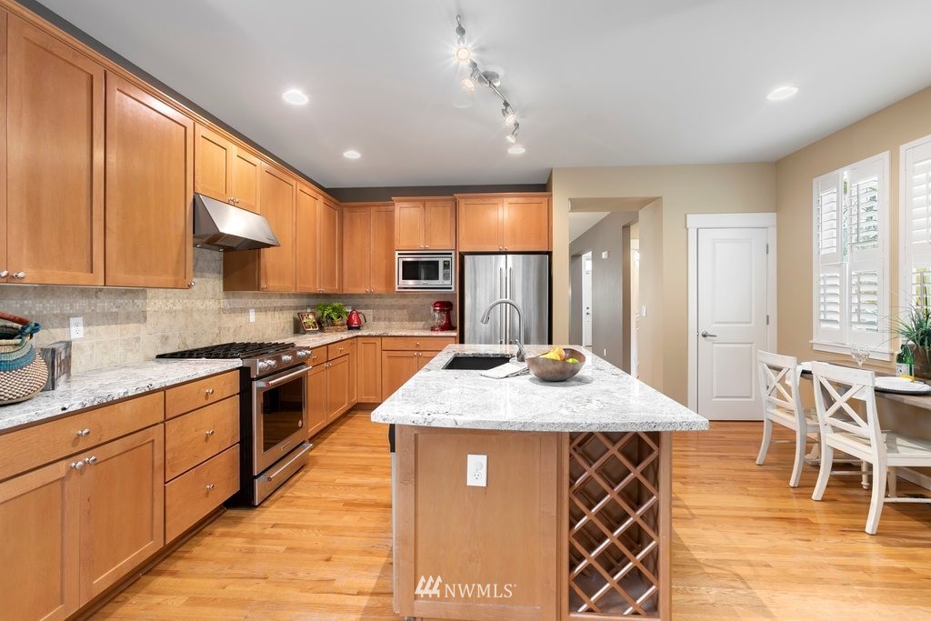 552 Mount Baker Place Northeast Renton, WA 98059 - Photo 8 of 25 a kitchen with stainless steel appliances granite countertop wooden cabinets a stove top oven a sink and dishwasher