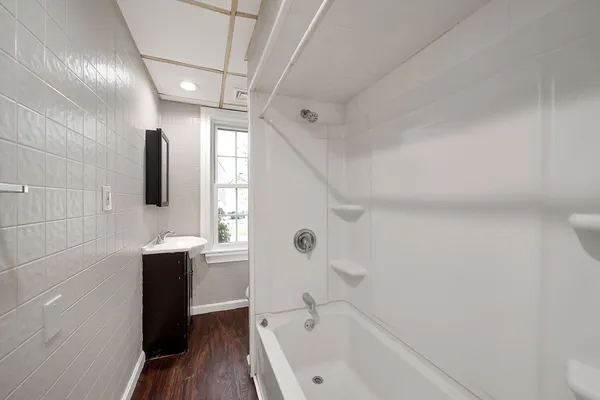 a bathroom with a bathtub shower sink vanity and toilet