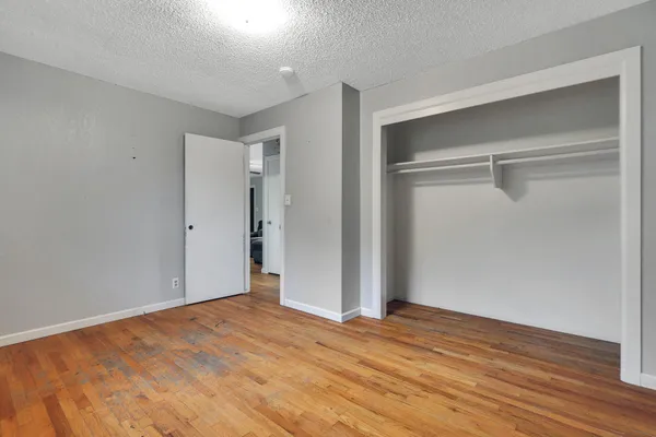 a view of empty room with wooden floor
