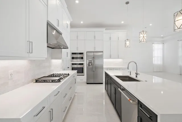 a kitchen with stainless steel appliances a sink a stove a microwave a counter top and cabinets