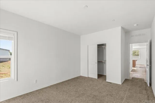 an empty room with windows and closet