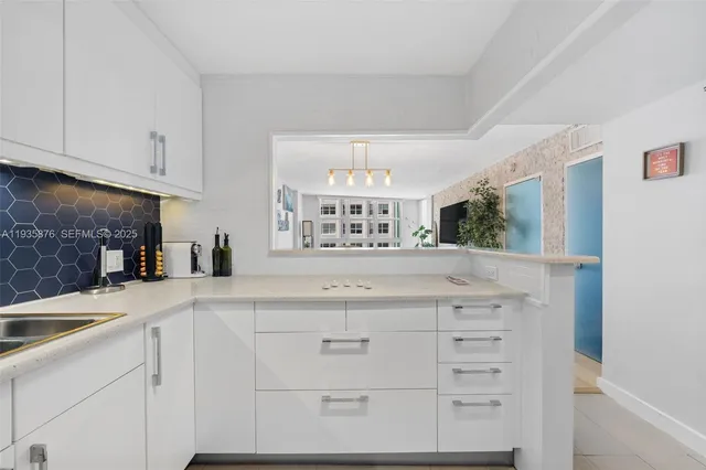 a kitchen with granite countertop white cabinets and a sink