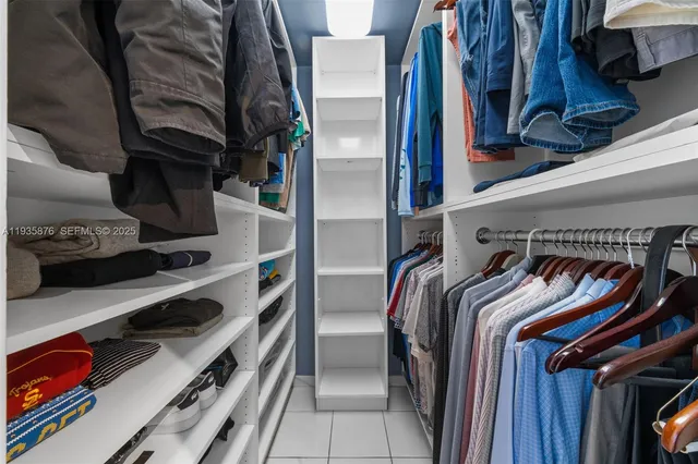 a view of walk in closet with clothes and shoes