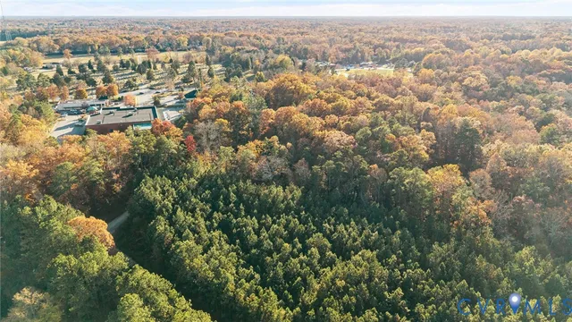 an aerial view of residential houses with city and green space
