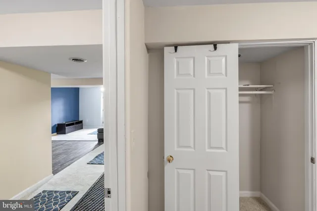 a view of a hallway with wooden floor and cabinet