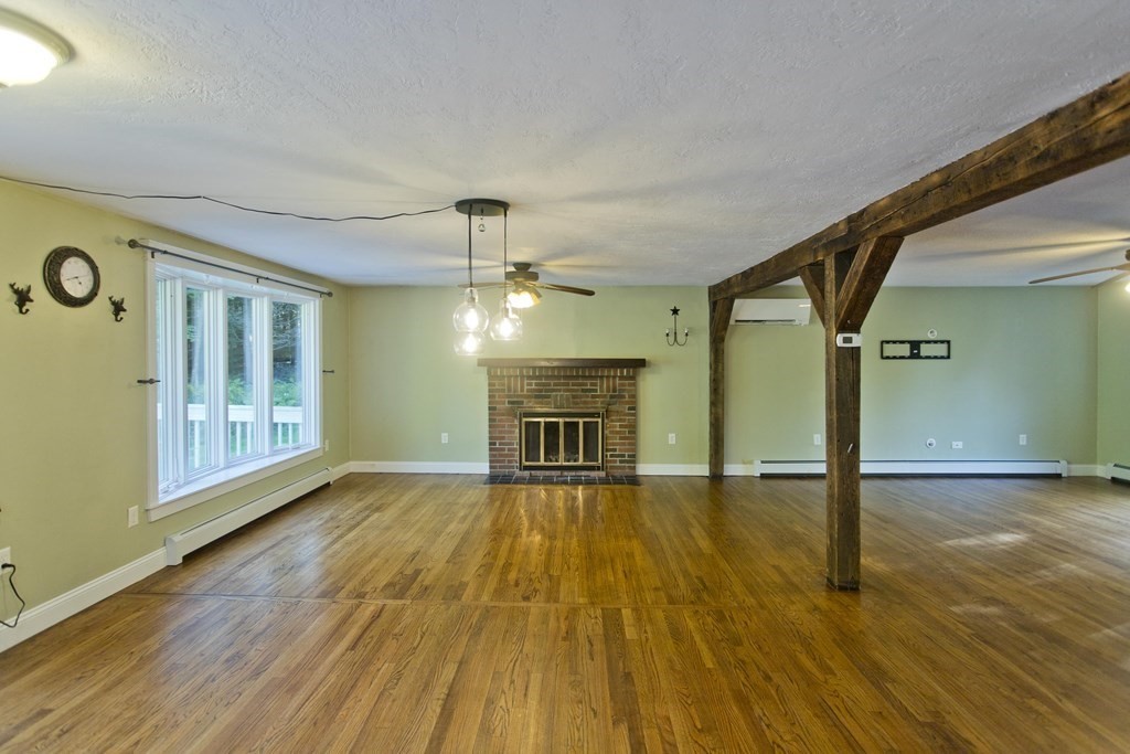 27 Searle Road Huntington, MA 01050 - Photo 13 of 32 a view of empty room with wooden floor and fireplace