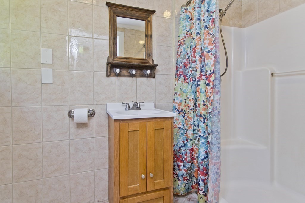 27 Searle Road Huntington, MA 01050 - Photo 16 of 32 a bathroom with a sink and mirror with shower curtain