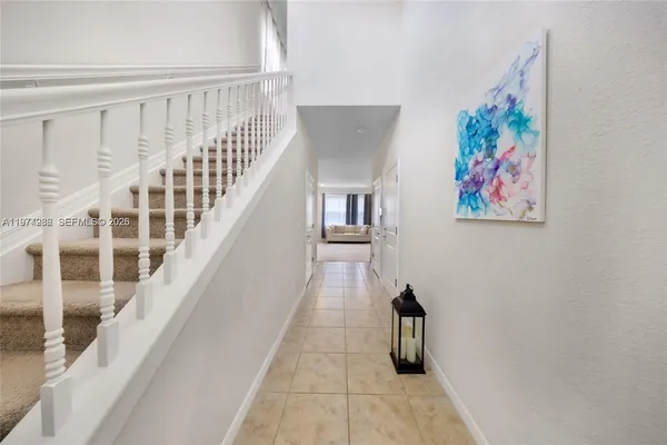a view of staircase with lots of frames on wall and a window