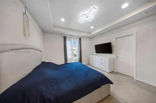 a bedroom with a bed tv and a window