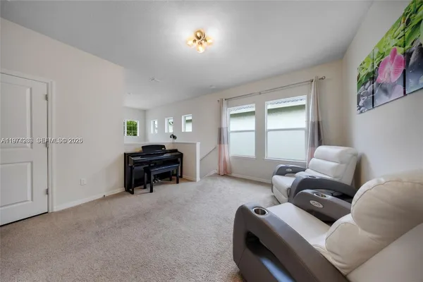 a living room with furniture and a piano