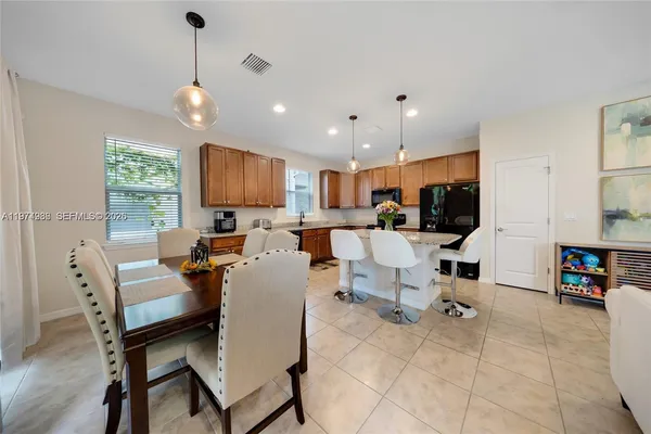 a living room with furniture kitchen view and a flat screen tv