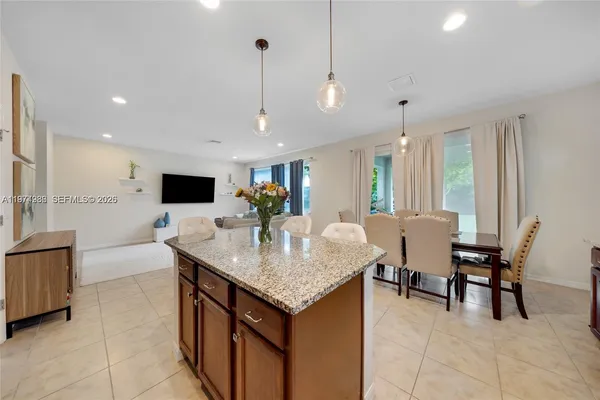 a kitchen with granite countertop a table and chairs in it