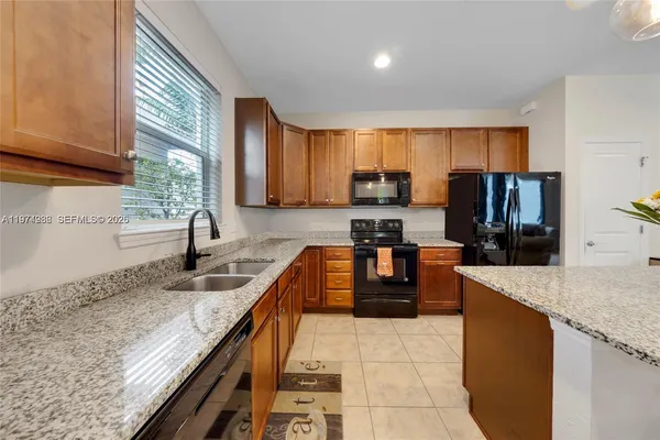 a kitchen with stainless steel appliances granite countertop a sink counter space cabinets and a large window