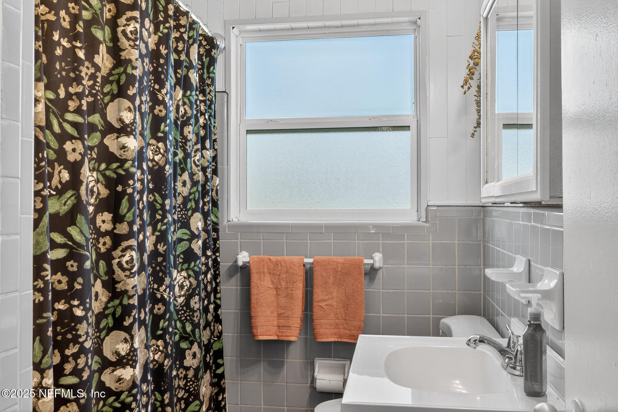 7470 Spinola Road Jacksonville, FL 32217 - Photo 35 of 76 a bathroom with a sink and a shower curtain