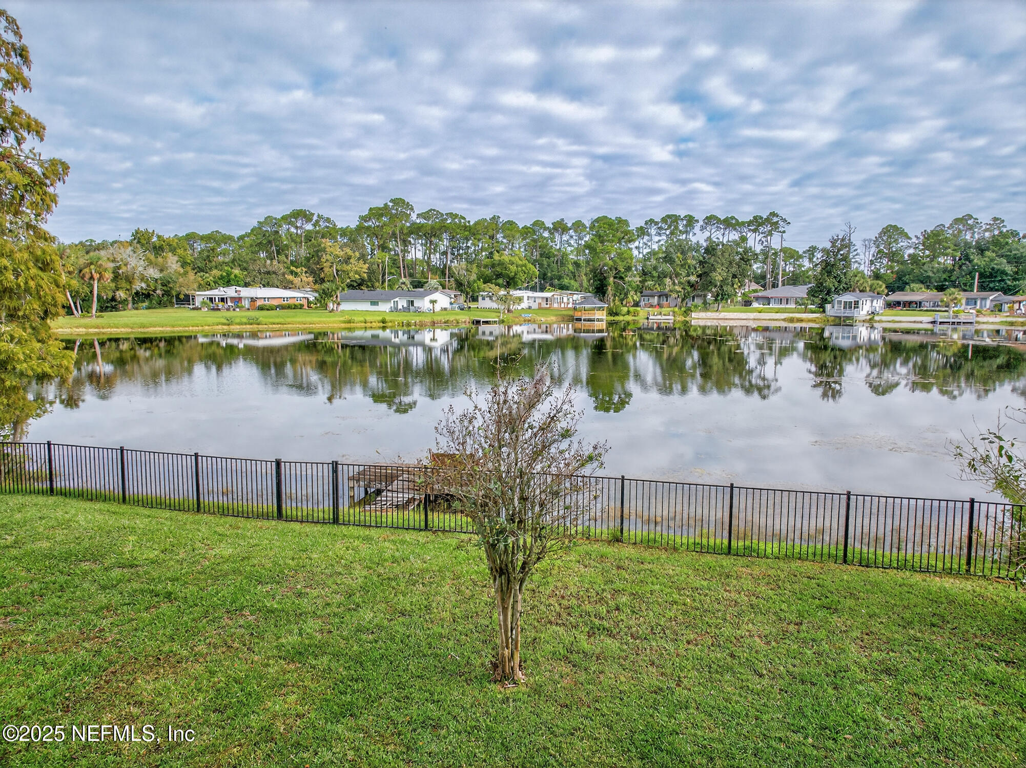 7470 Spinola Road Jacksonville, FL 32217 - Photo 4 of 76 a view of a lake with a big yard and large trees