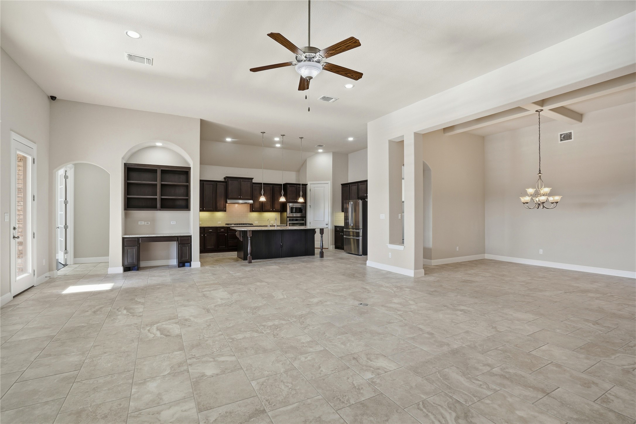 4109 Haight Street Round Rock, TX 78681 - Photo 13 of 40 Unfurnished living room with arched walkways, a ceiling fan, and hanging lights