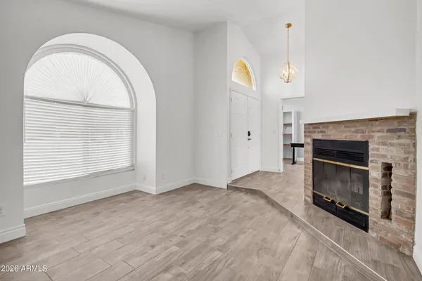 a view of empty room with a fireplace and wooden floor