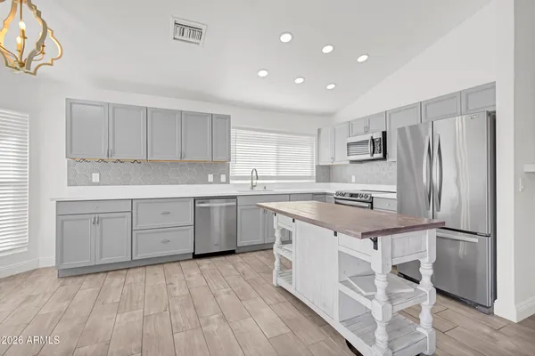 a kitchen with a refrigerator a sink and cabinets