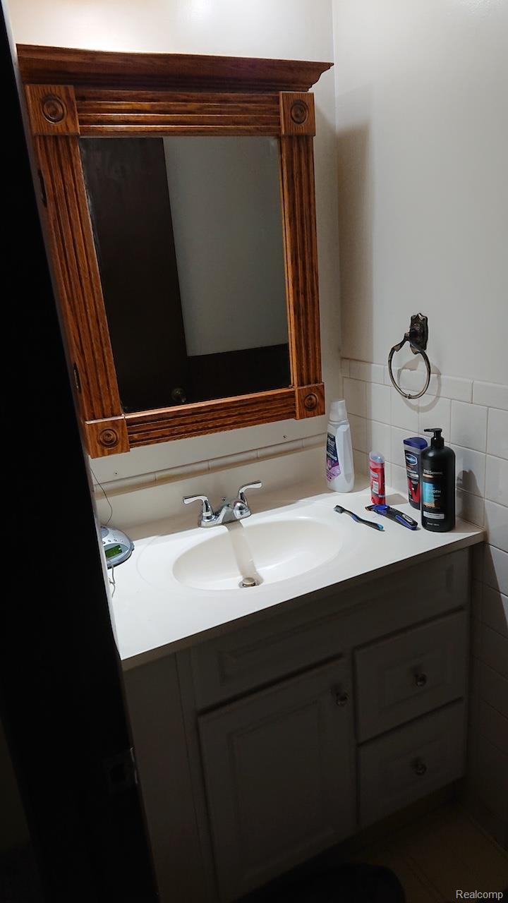 White vanity with dual cabinet doors and two drawers, featuring a built-in sink and chrome faucet