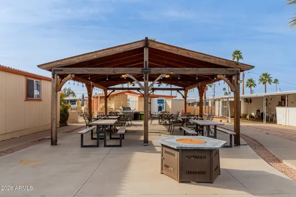 a view of patio with table and chairs under an umbrella with a barbeque