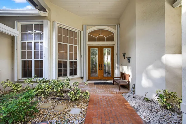 a living room with furniture a chandelier and a large window