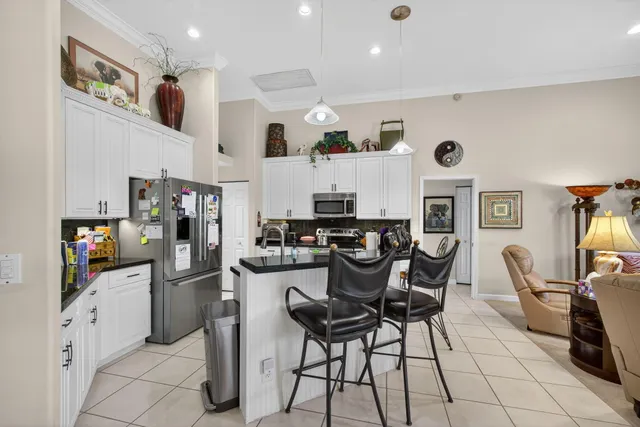 a living room with furniture a chandelier and a flat screen tv