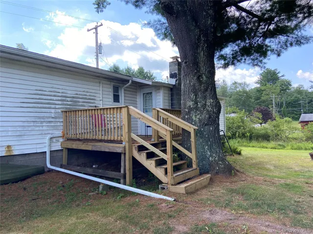 a view of a backyard with a large tree and wooden fence