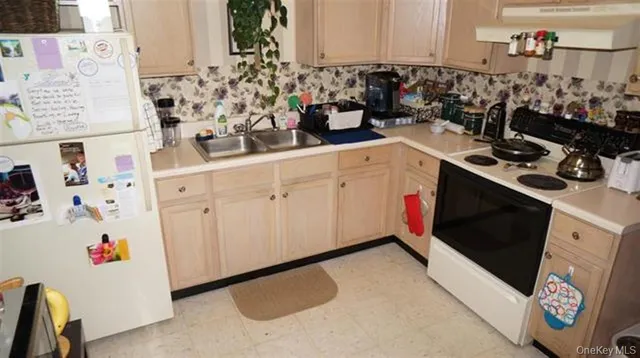 a kitchen with stainless steel appliances a stove and white cabinets