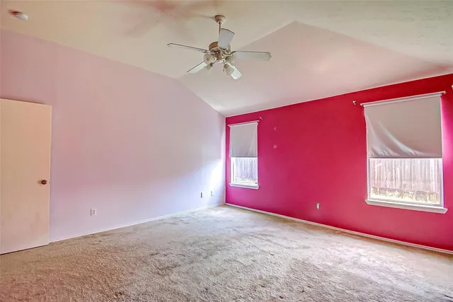 a big room with chandelier fan and windows