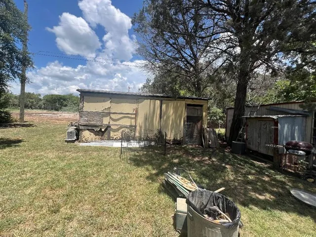 a backyard of a house with table and chairs