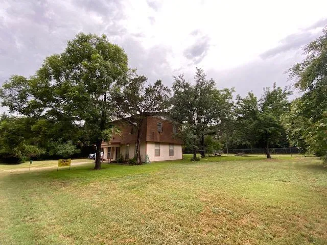 a view of a house with a yard and a tree
