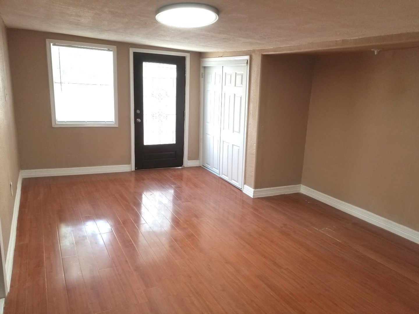 4714 Sharon Street Houston, TX 77020 - Photo 3 of 11 an empty room with wooden floor and windows